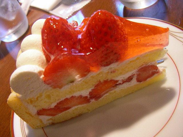 cake with bananas and strawberries sitting on top of a white plate