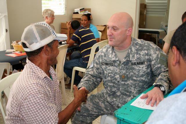 two men are shaking hands while others are seated