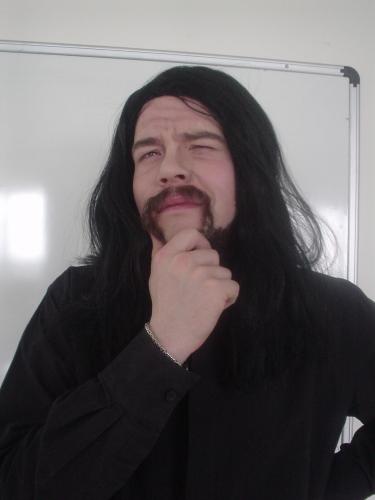 a man with long black hair and a moustache and a fake mustache