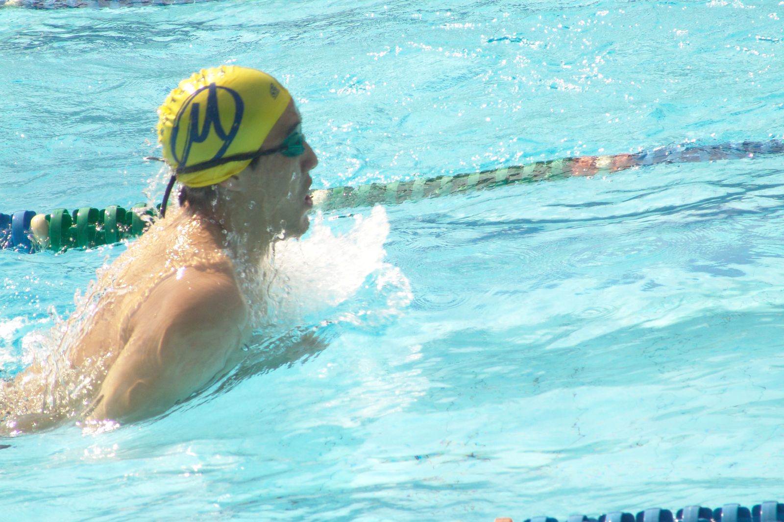 a male swimmer in the pool with a ball on his head
