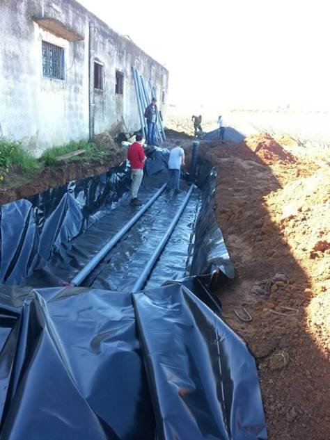 a large black tarp covers a building and train tracks