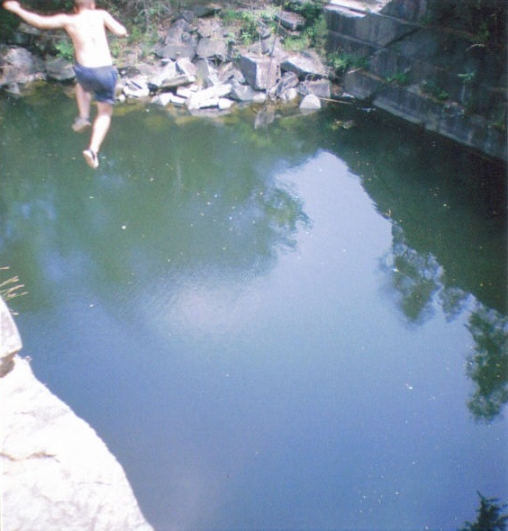 a person that is jumping off of a cliff in the water