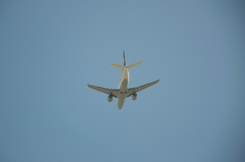 an airplane flying in the sky and looking back at the camera