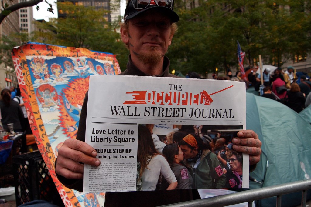 a person holding a newspaper in front of a crowd of people