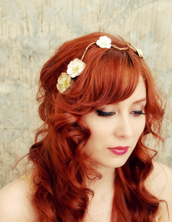 the woman is wearing long red hair and flowers in her hair