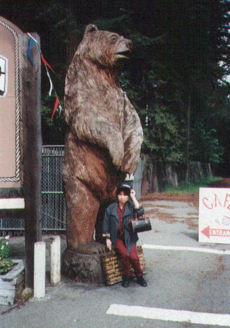 a man standing in front of a giant bear statue