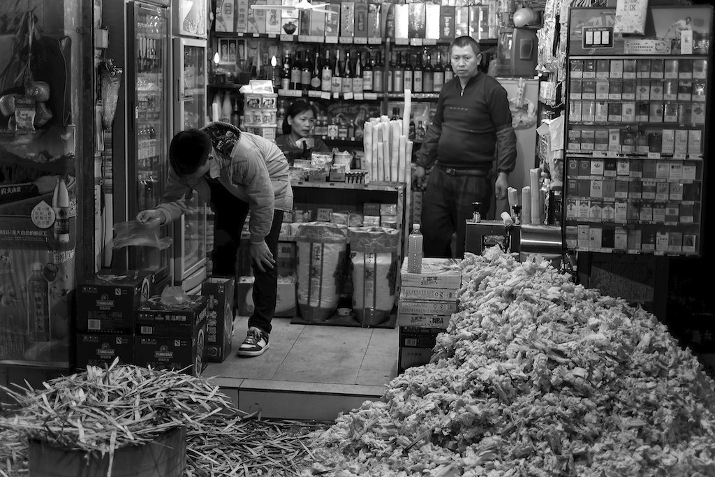 men in a flower shop looking into one of the store's glass doors