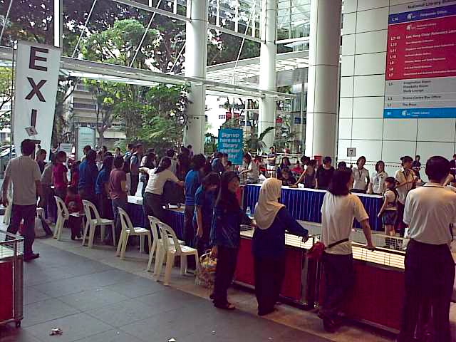 group of people standing around tables with white chairs