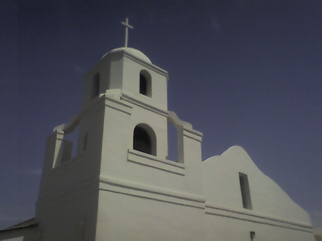 the front of a white church with a cross on it