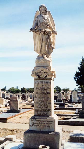 a statue in a graveyard with several heads on it