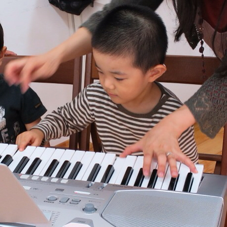 three children playing with a musical keyboard