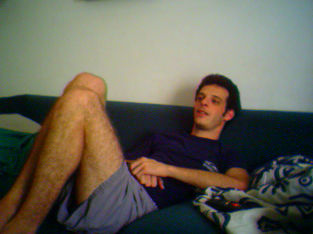 a man in shorts is sitting on a couch