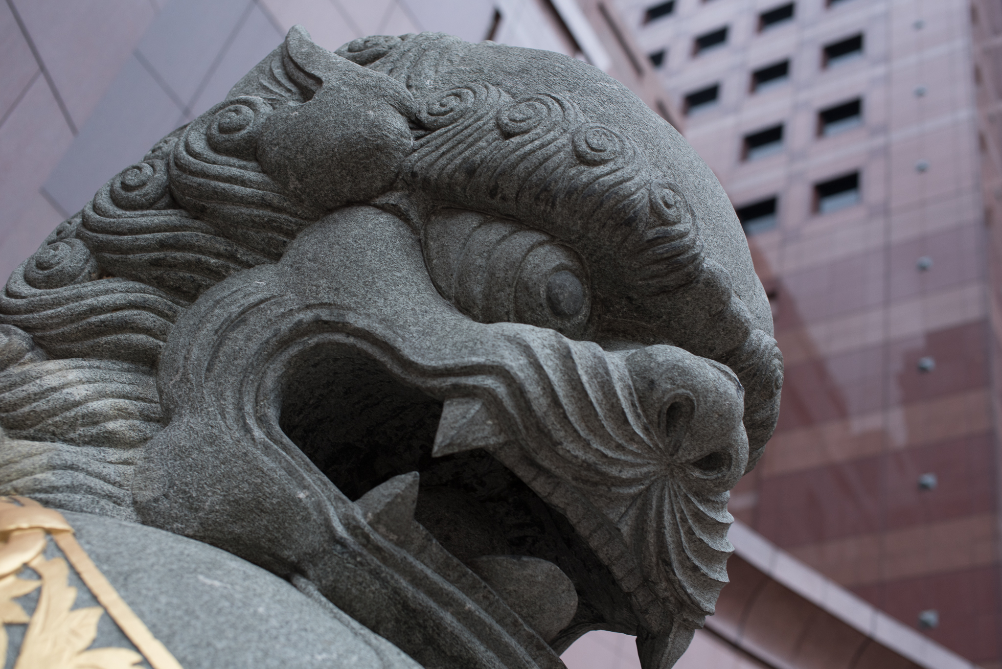 statue with dragon and lion heads on the side of a building