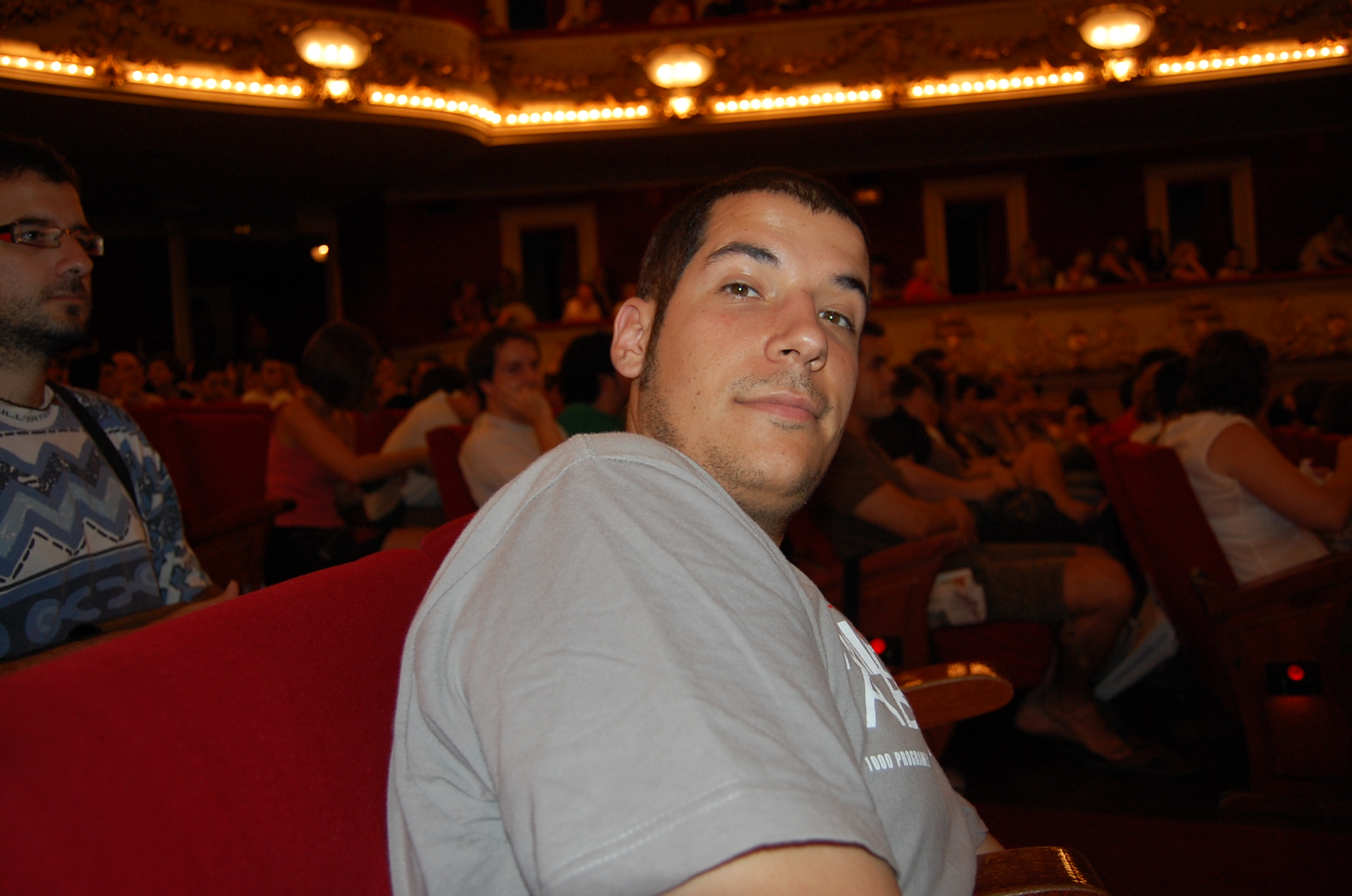 a man sits on an auditorium chair and looks ahead