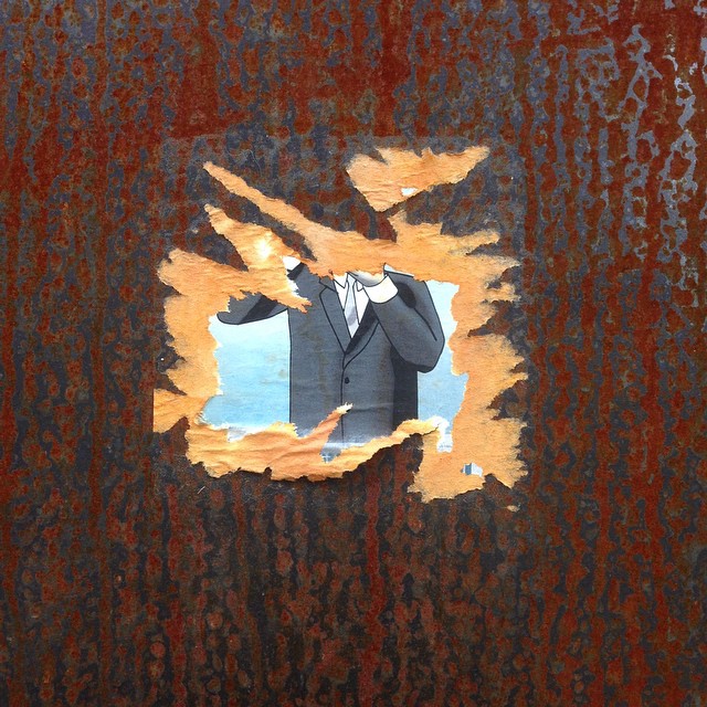 a rusty wall that is rusted and has a sticker on it