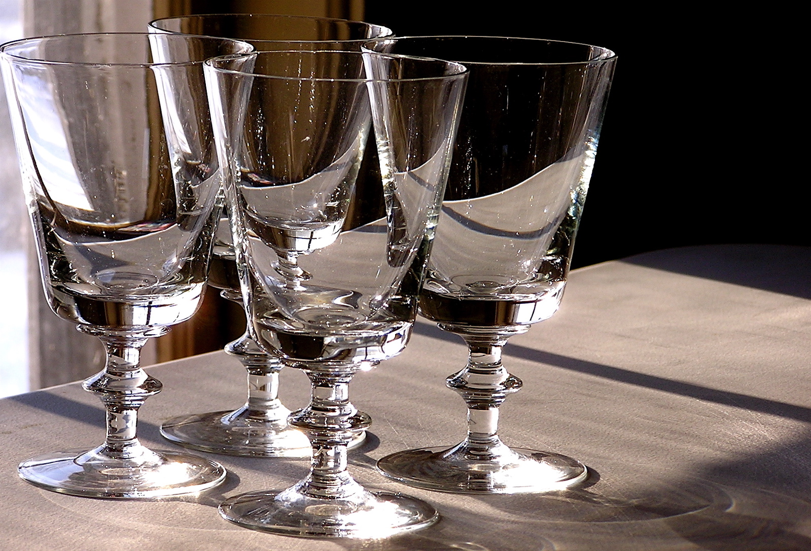 three clear wine glasses on a brown table
