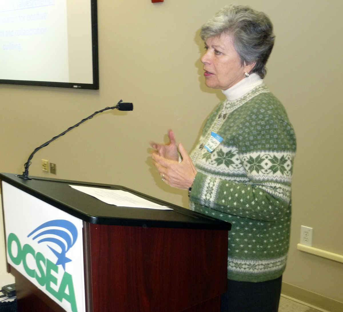 a woman is speaking at a podium