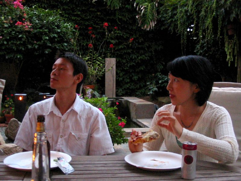 two people sitting at a table outdoors at night