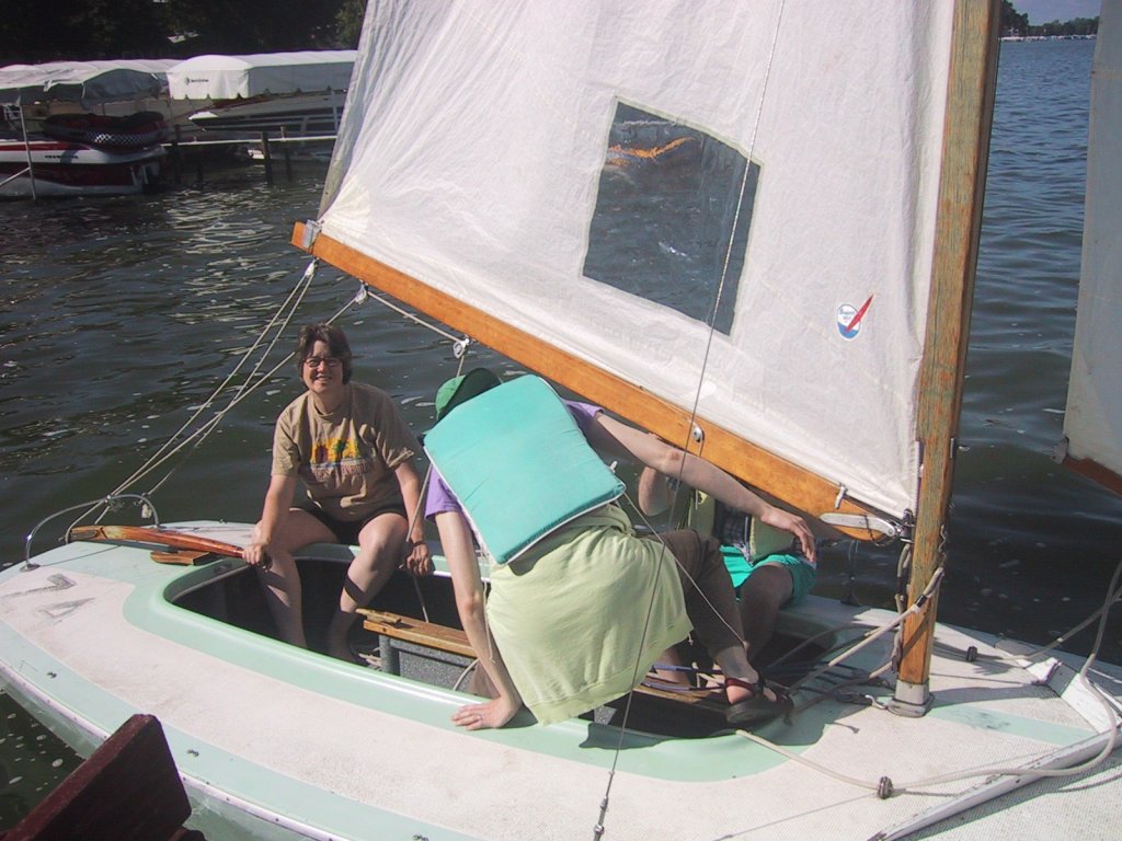 some people are sitting on the back of a sail boat