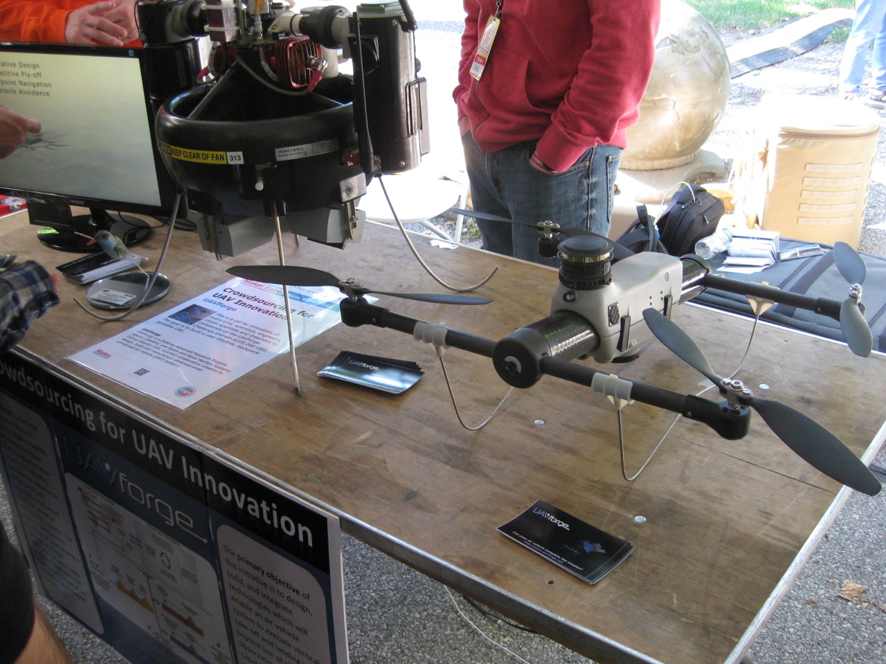 a table that has a table top on it with electronics and people around