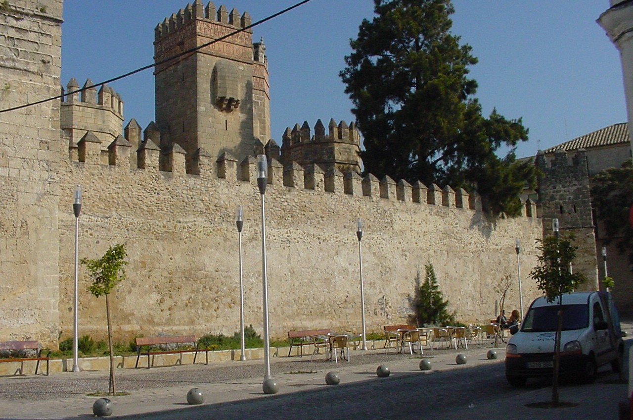 a car is parked in front of an ancient stone wall