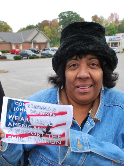 woman in denim shirt and hat holding sign for the republican