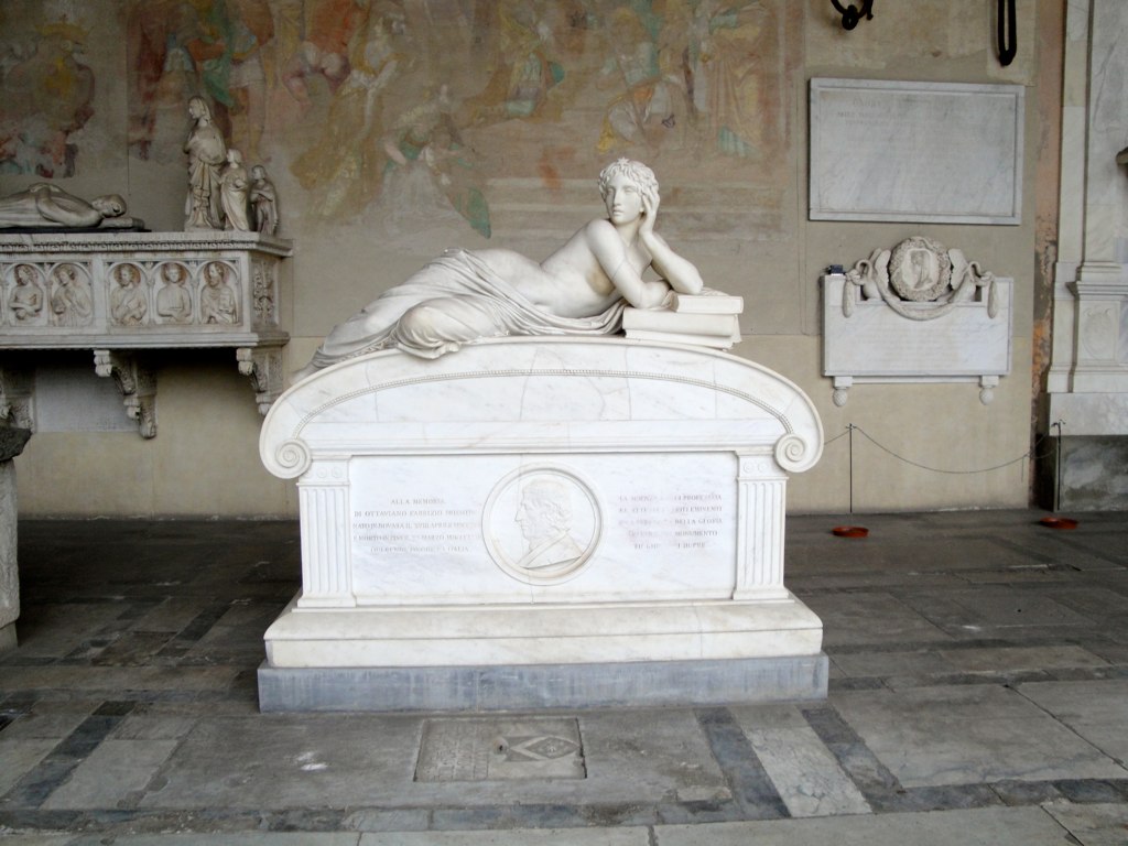 a marble statue laying on a floor next to some sculptures
