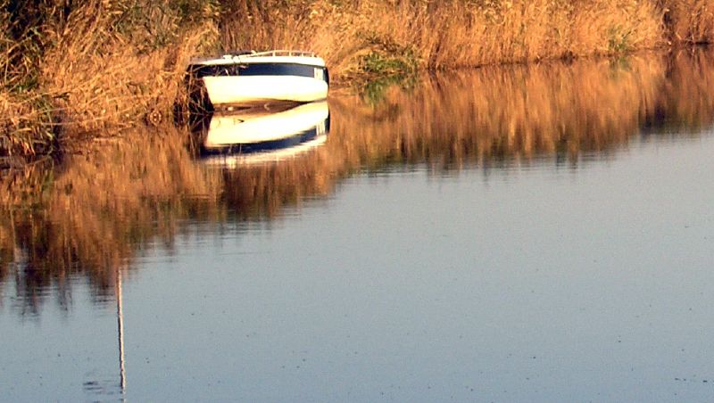 two boats in a ditch near some water