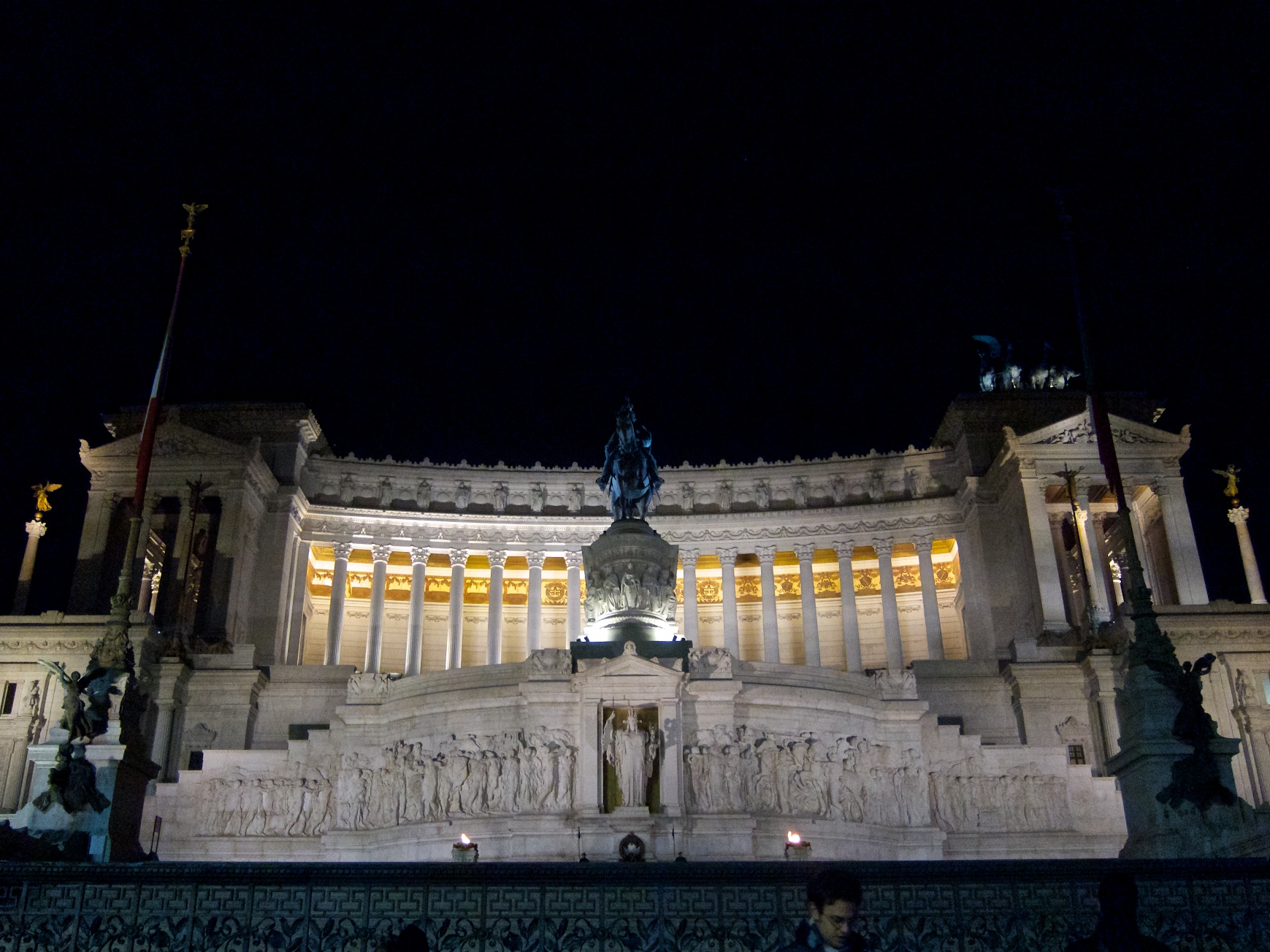 a building at night with a statue and a monument