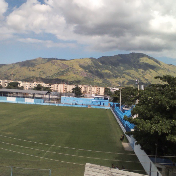 a view of a soccer field with mountains in the background