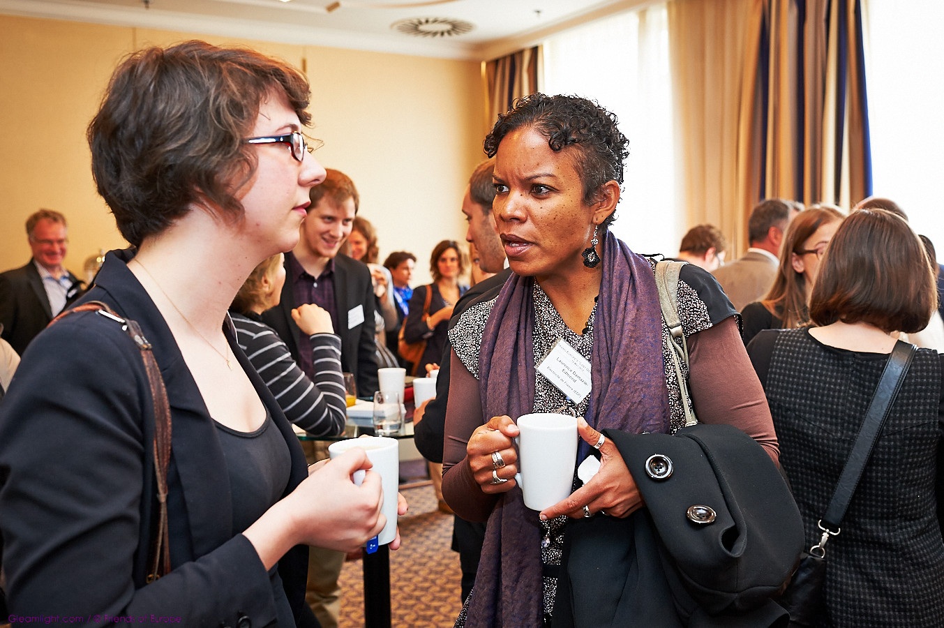 two women are talking while having conversation at an event