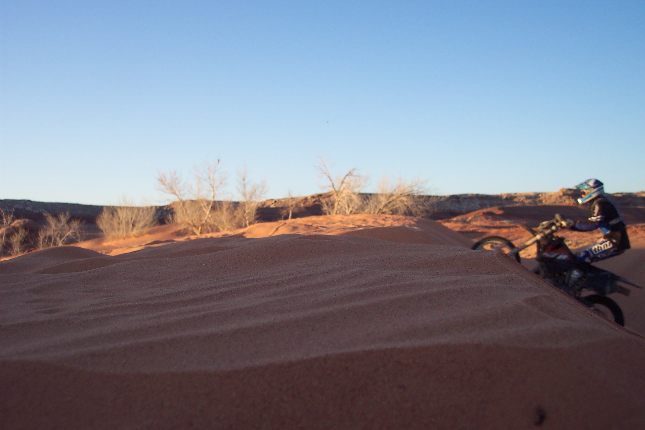 a person on a dirt bike jumping in the sand