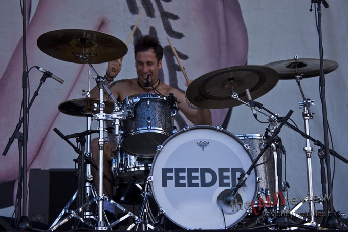 a man holding drums on stage during a music festival