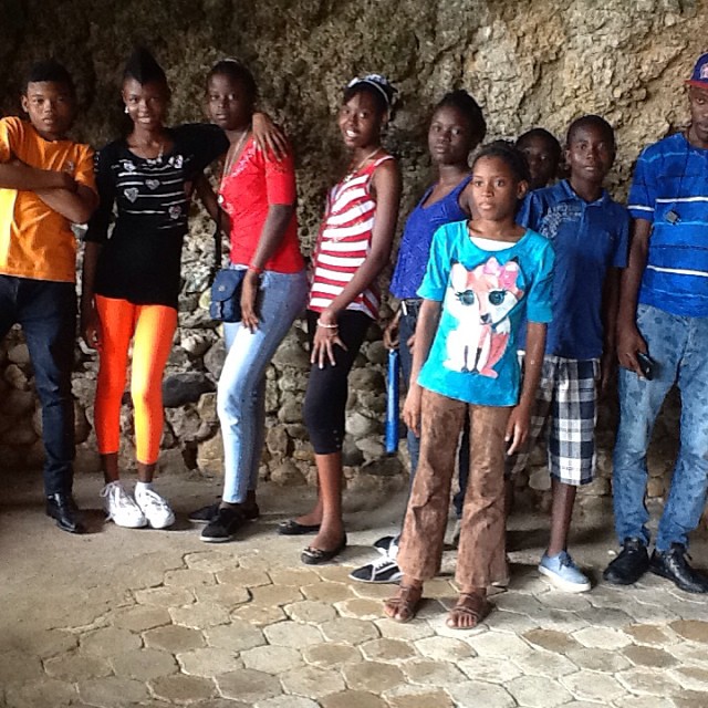 a group of young children pose together in a cave