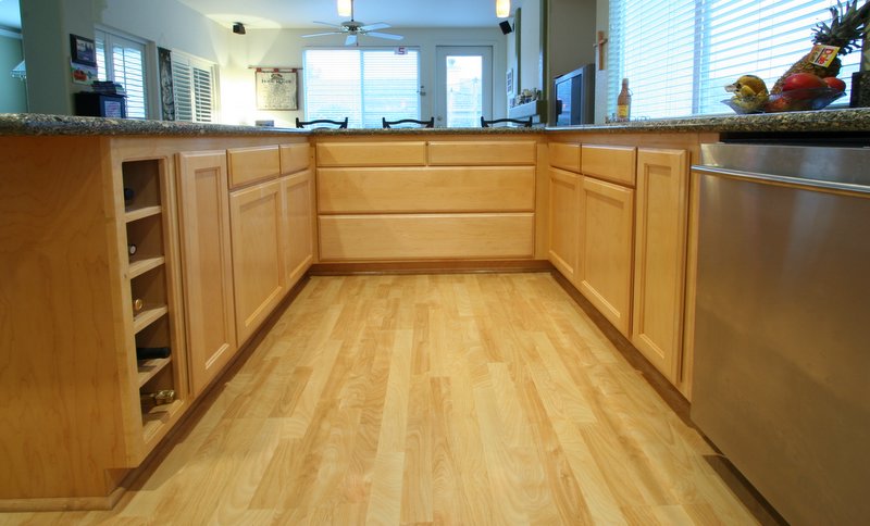 a kitchen area with hard wood floors and tile counter tops