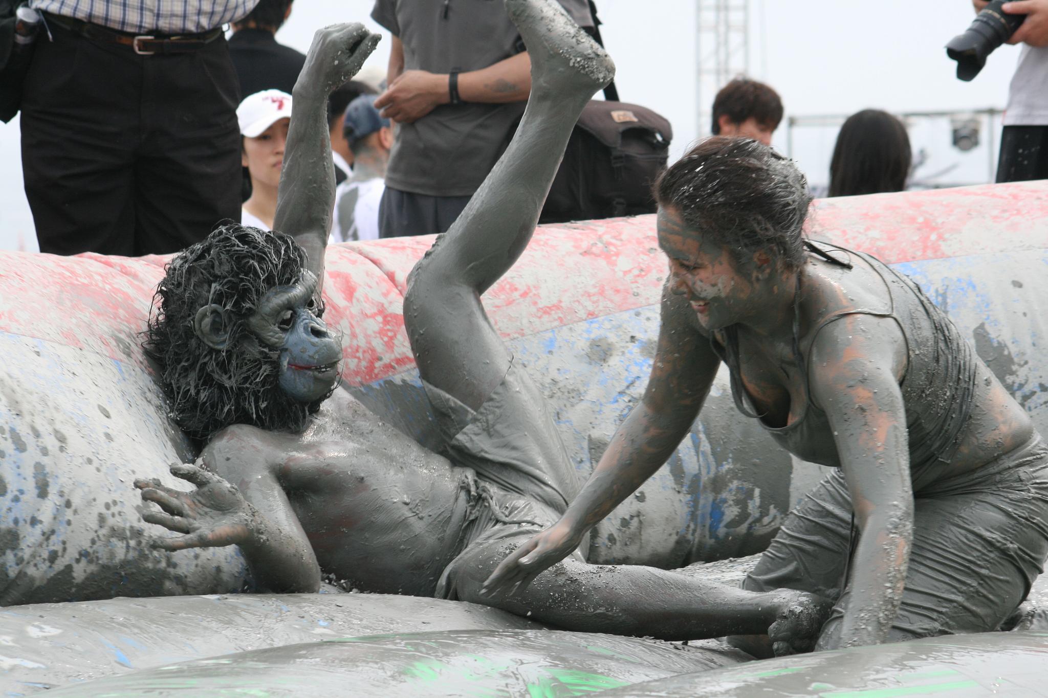 two girls are playing in the mud in a pool of water