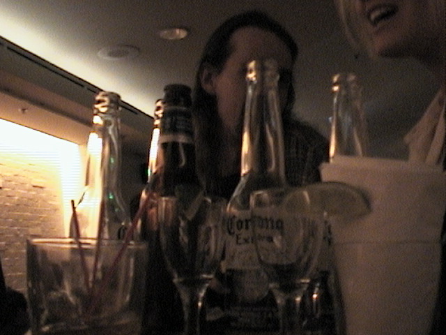 man at a bar with a lot of liquor bottles and glasses on the table