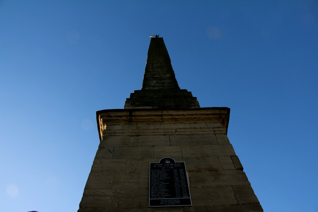 a large stone tower sitting above a group of people