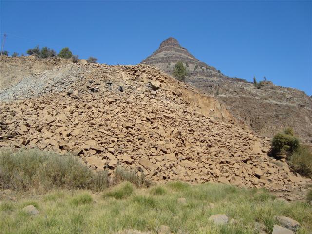 many large mounds of sand are on the side of a mountain