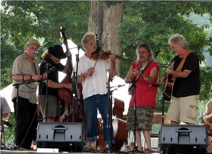 a group of men standing next to each other holding guitars