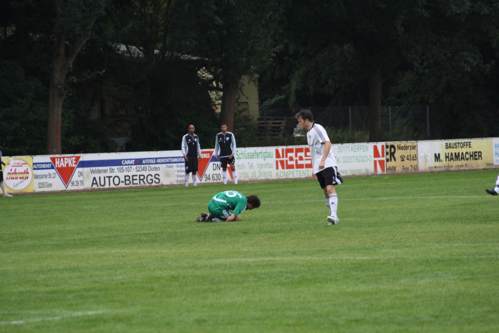 several soccer players with one laying down on the grass