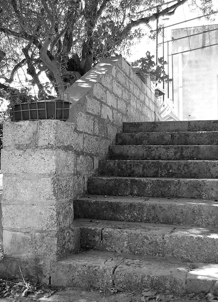 a black and white image of a cement wall with stairs