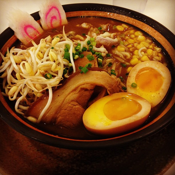 a bowl full of noodles and meats with an egg