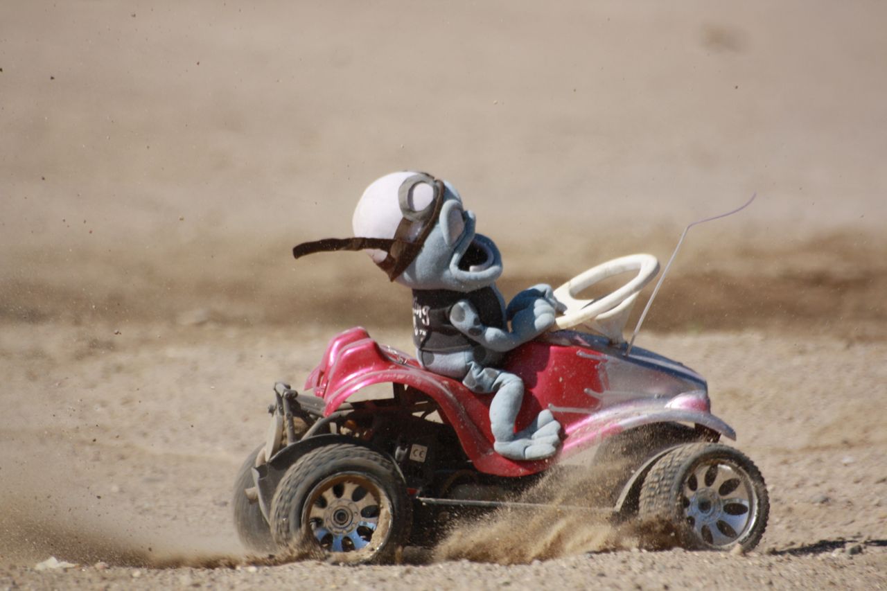 a child's toy car driving in the sand