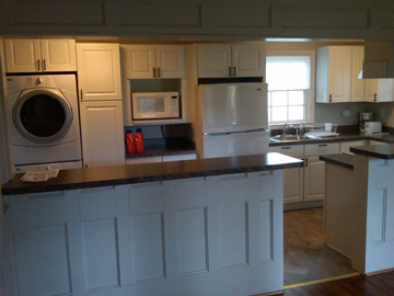 an open kitchen area with washer and dryer in it