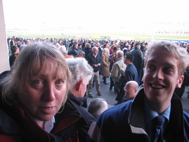 two people standing at the front of a race track with an audience behind them