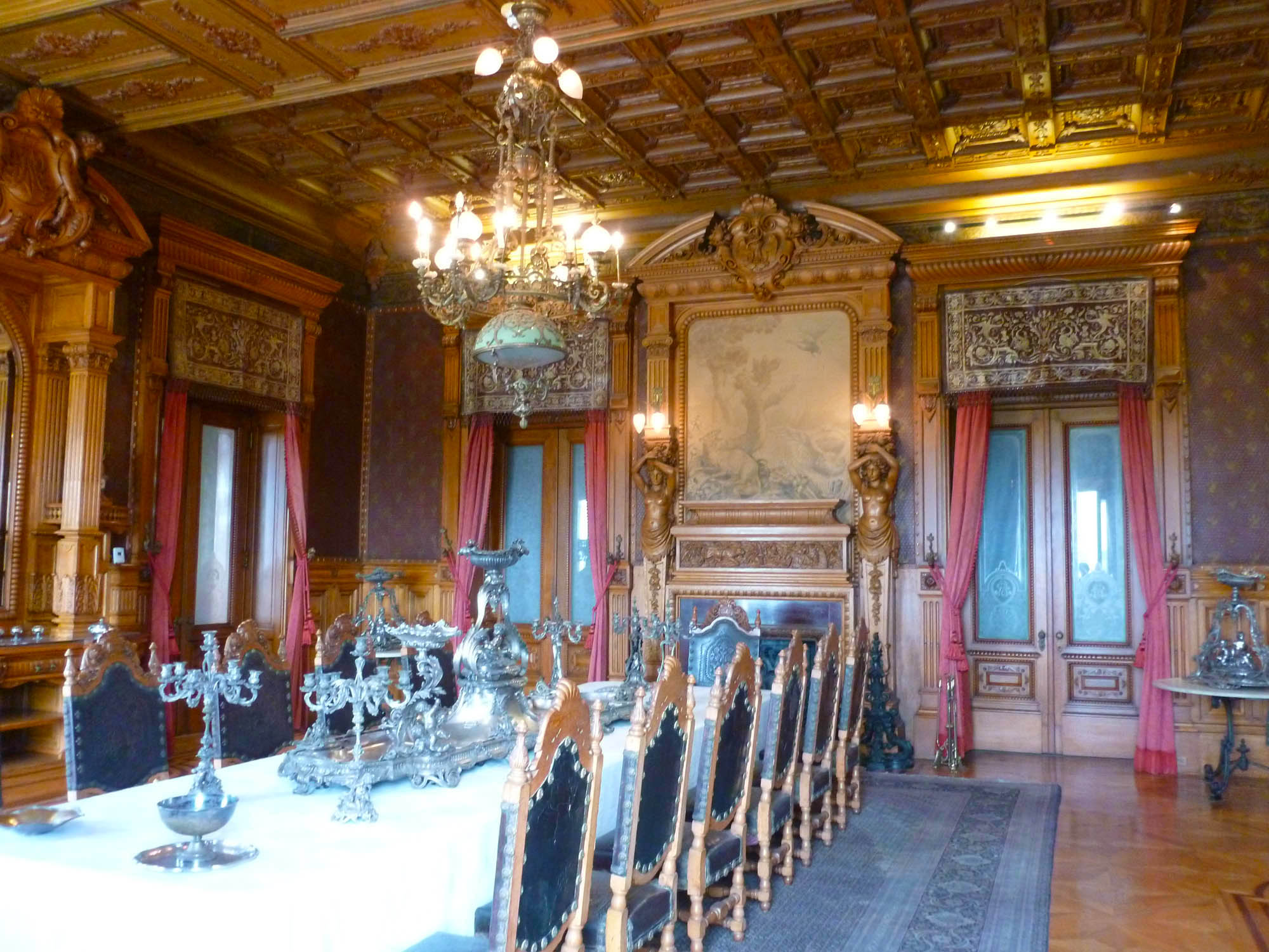 fancy dining room with chairs, chandelier, and fancy painting