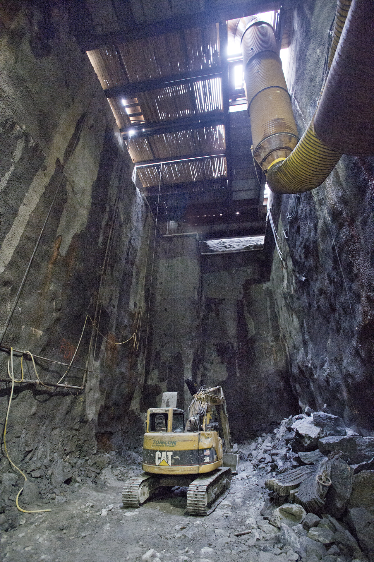 a small, crawl crawling machine is in an old concrete pipe laying next to it