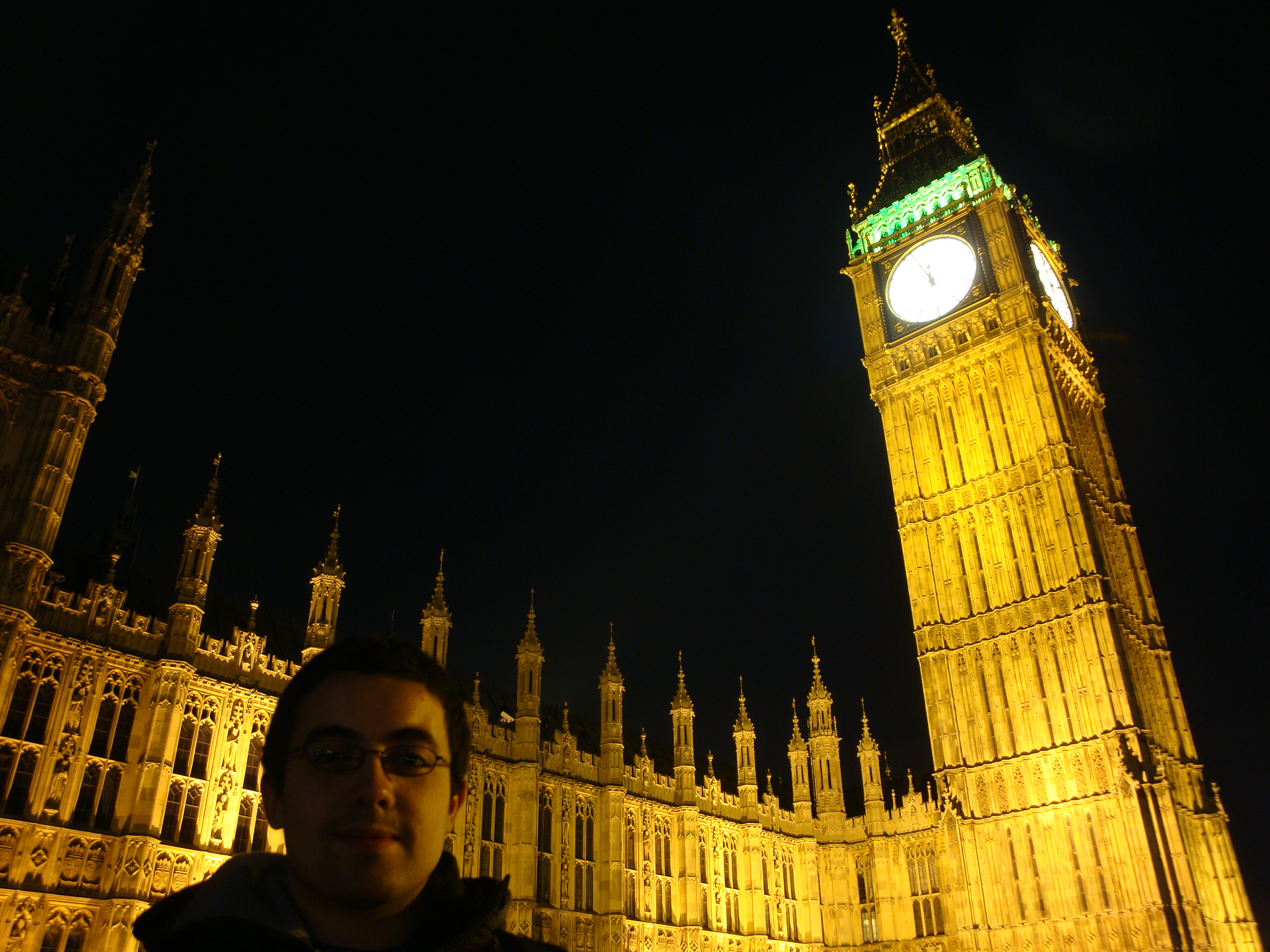 a man with glasses in front of the building