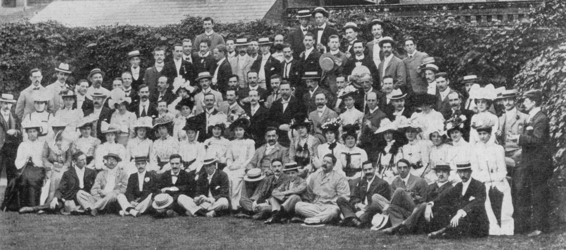 a group of people and men standing in front of some bushes